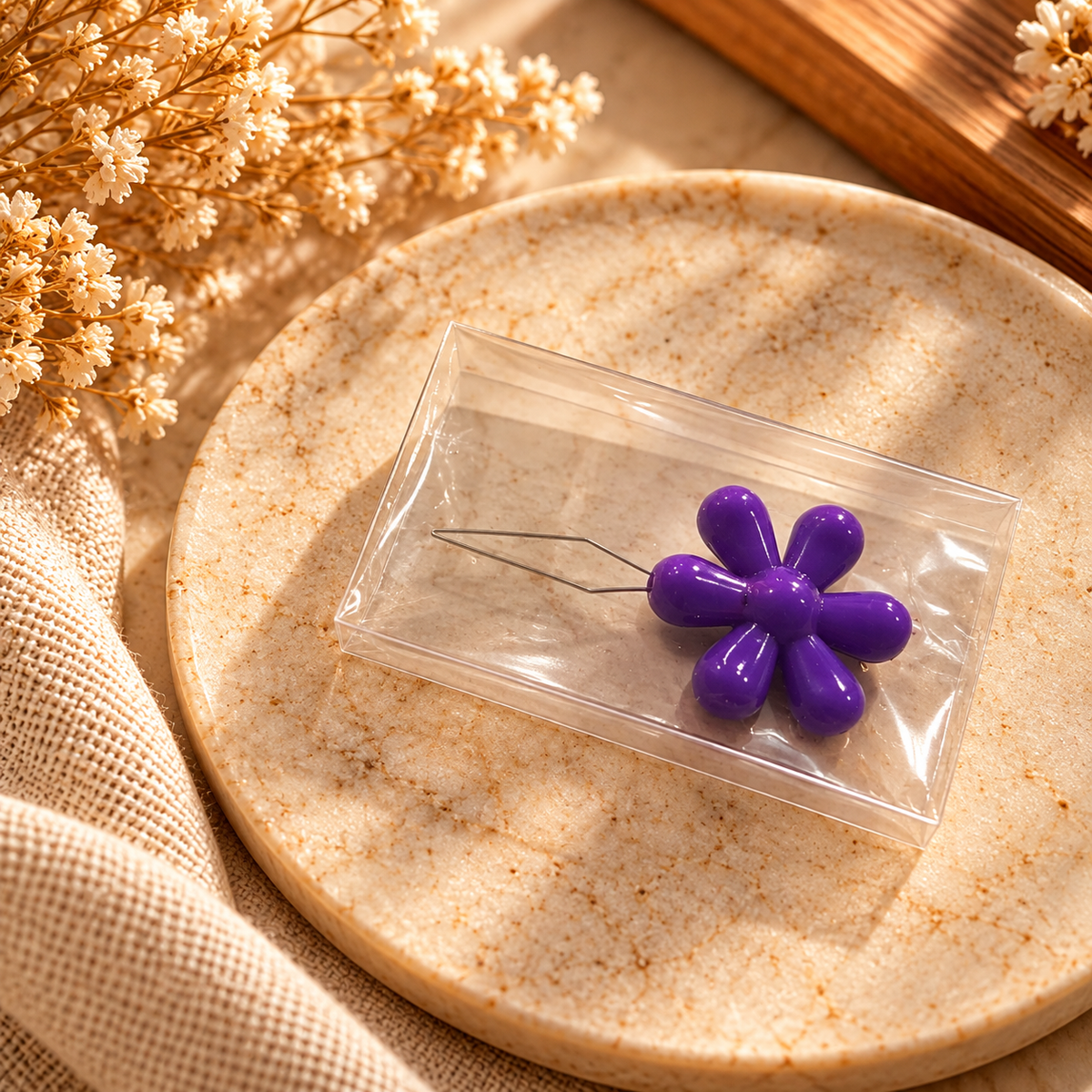 Purple flower-shaped needle threader with a fine wire threading loop