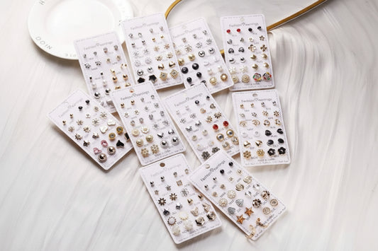 Assorted earring sets on display cards on a white surface