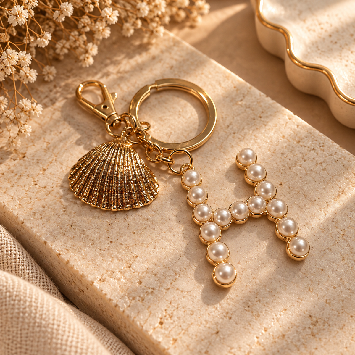 Gold-tone seashell keychain with pearl-style letter H charm