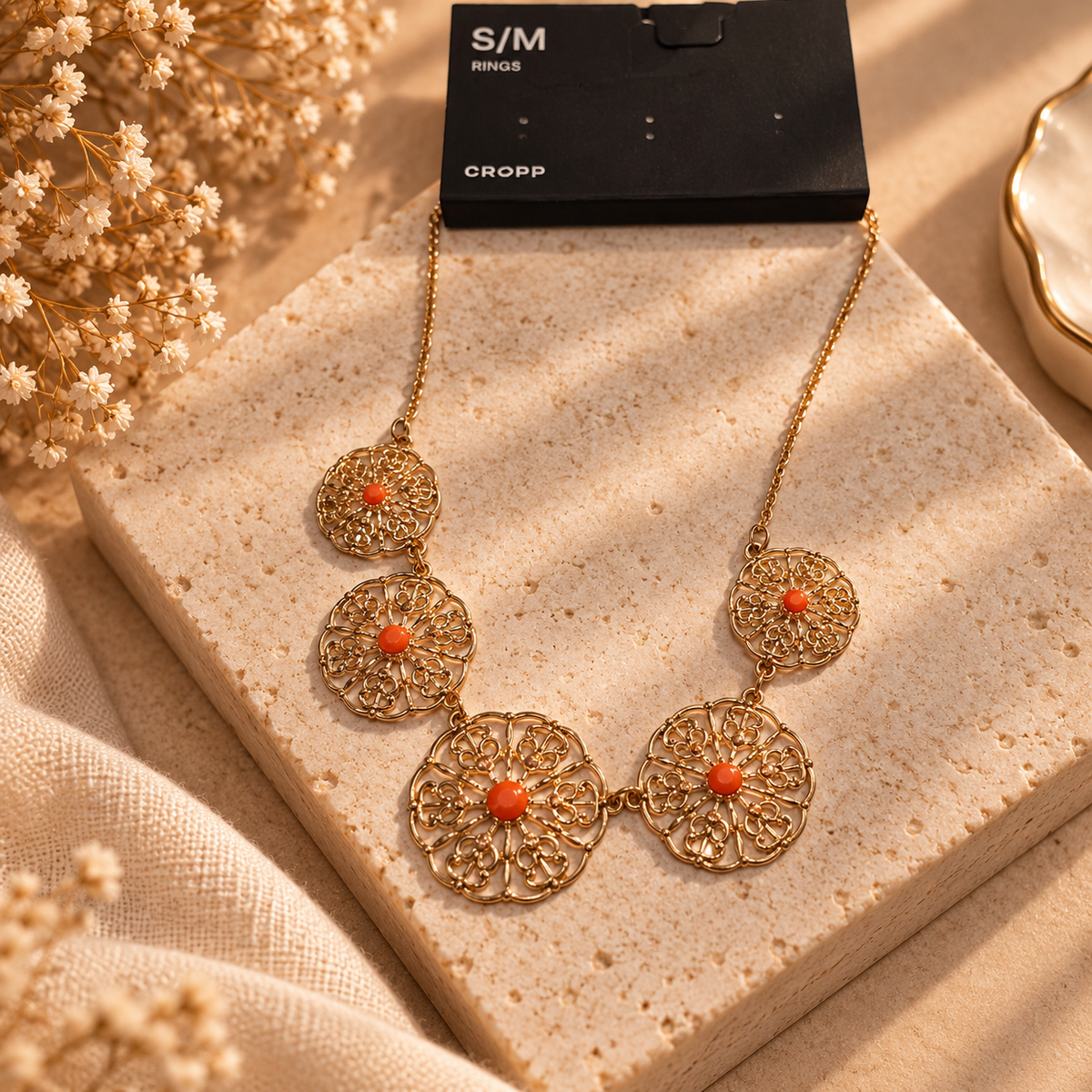 Gold-tone filigree statement necklace with floral circles and orange accents