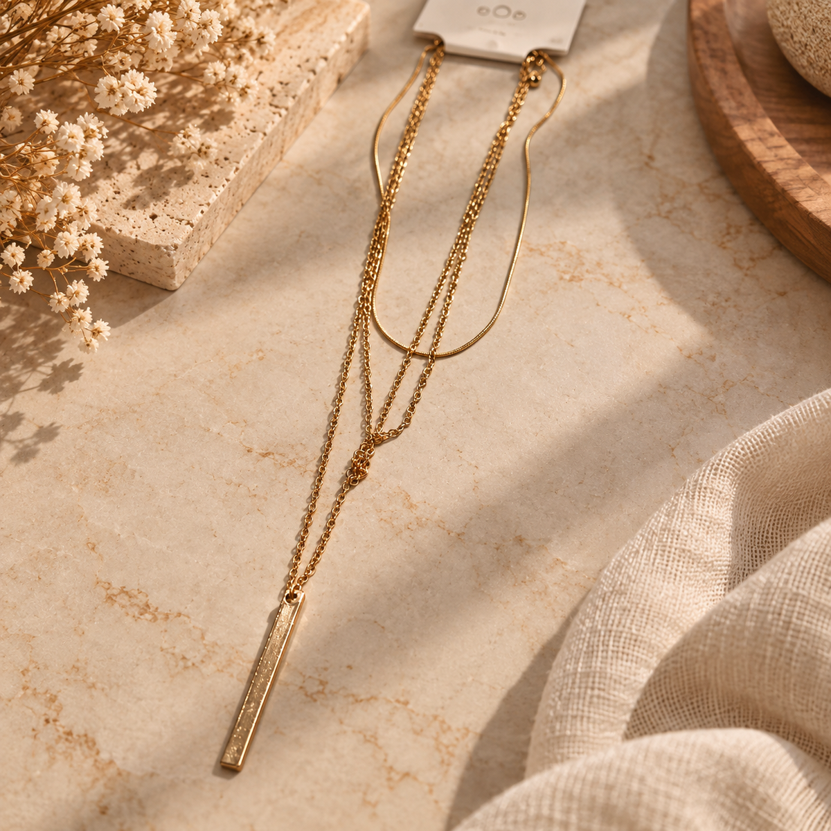 Gold-tone multi-layered necklace with a sleek rectangular bar pendant