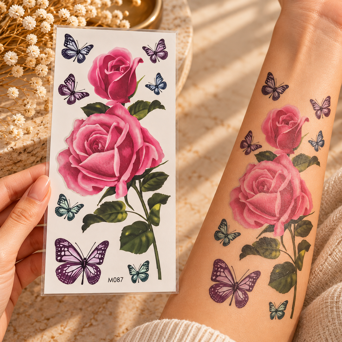 Large pink rose and butterfly temporary tattoo sheet shown applied to a forearm