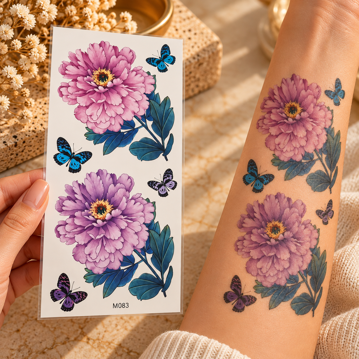 Large pink peony and butterfly temporary tattoo sheet shown applied to a forearm