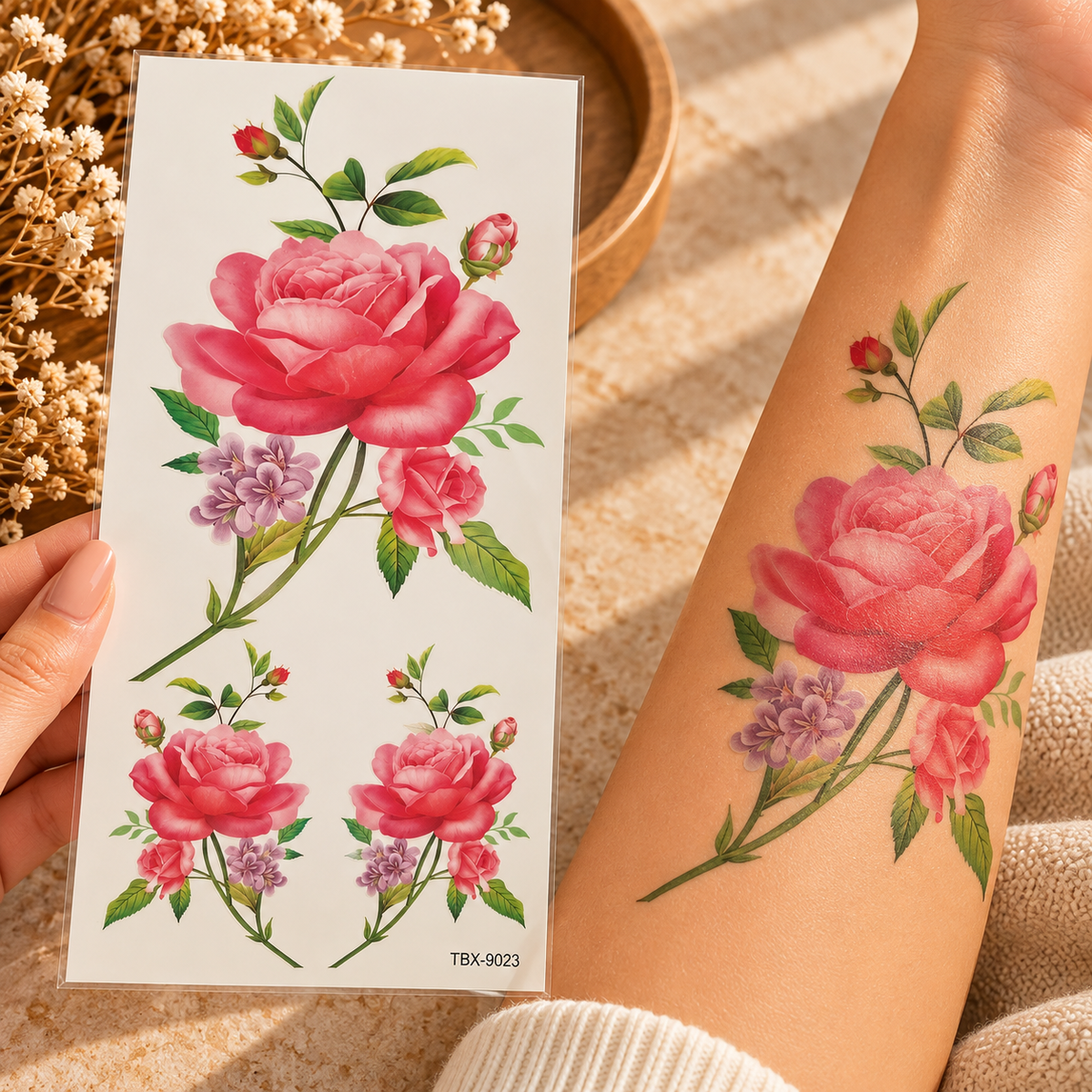Pink rose and purple flower temporary tattoo sheet with one large and two smaller floral arrangements, shown on an arm