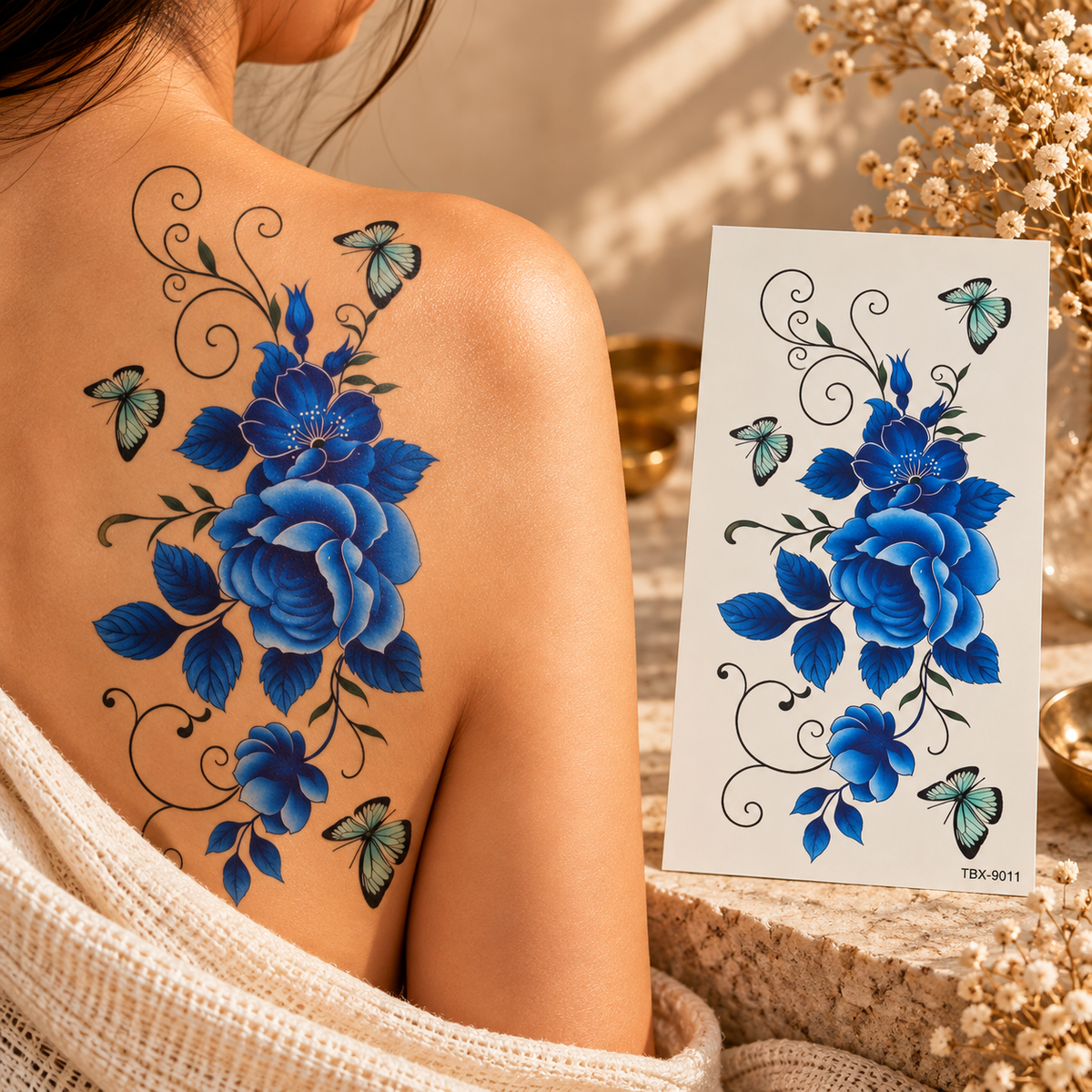 Blue floral and butterfly temporary tattoo with swirling vine details, shown on a shoulder and on its sheet