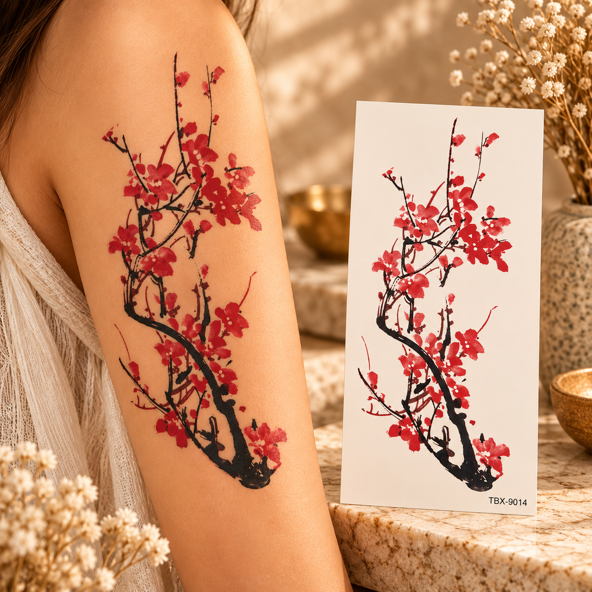 Red cherry blossoms on a dramatic black tree branch temporary tattoo shown on an arm and on its sheet
