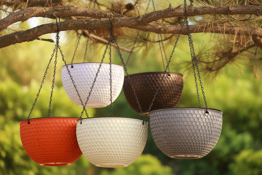 Set of five hanging flower pots with textured surfaces and chains against a blurred natural background.