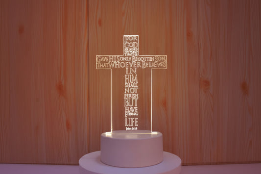 Cross-shaped LED lamp with text on a wooden background